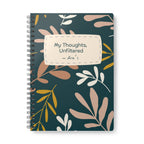A5 spiral notebook with teal cover, botanical pattern, and label reading My Thoughts, Unfiltered