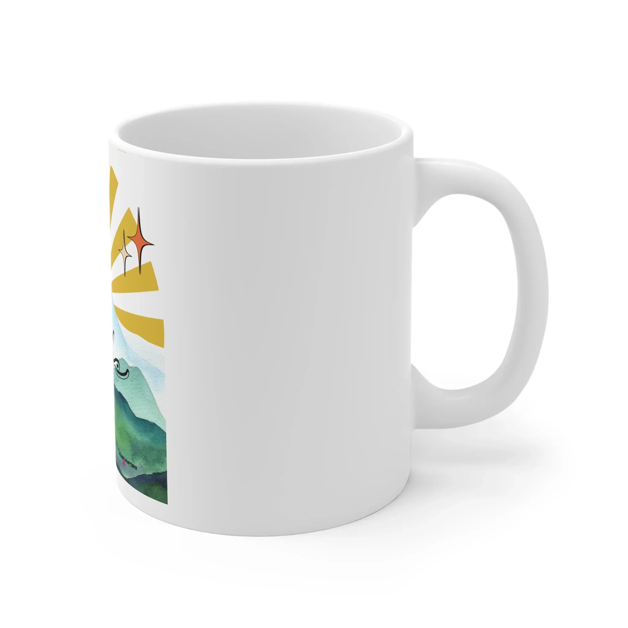 White coffee mug with landscape-and-sunrise print visible along the side