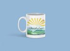 White coffee mug with sunrise rays and mountain landscape graphic, front view