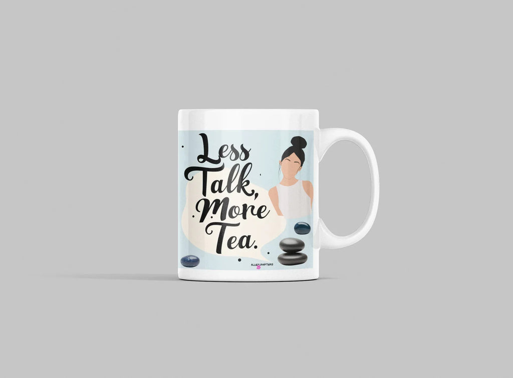 White tea mug on light gray surface with 'Less Talk, More Tea' print