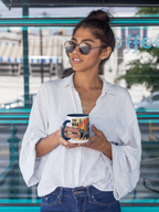 Printed ceramic tea mug with flaming cat graphic, held in hands