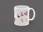 White ceramic mug with custom name “Sarah” and pink XO heart accents