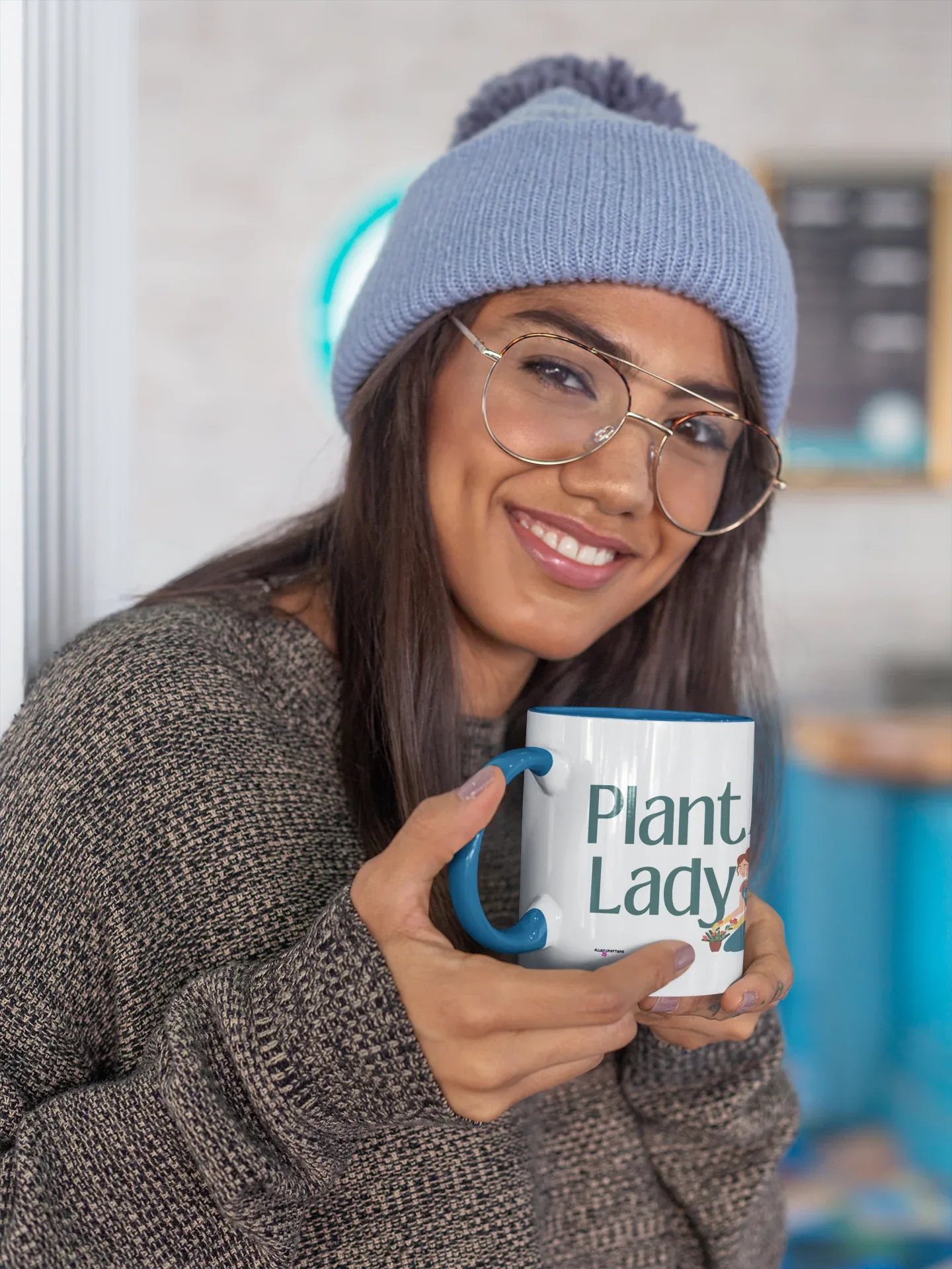 White coffee mug with “Plant Lady” graphic, held by a woman in a blue hat