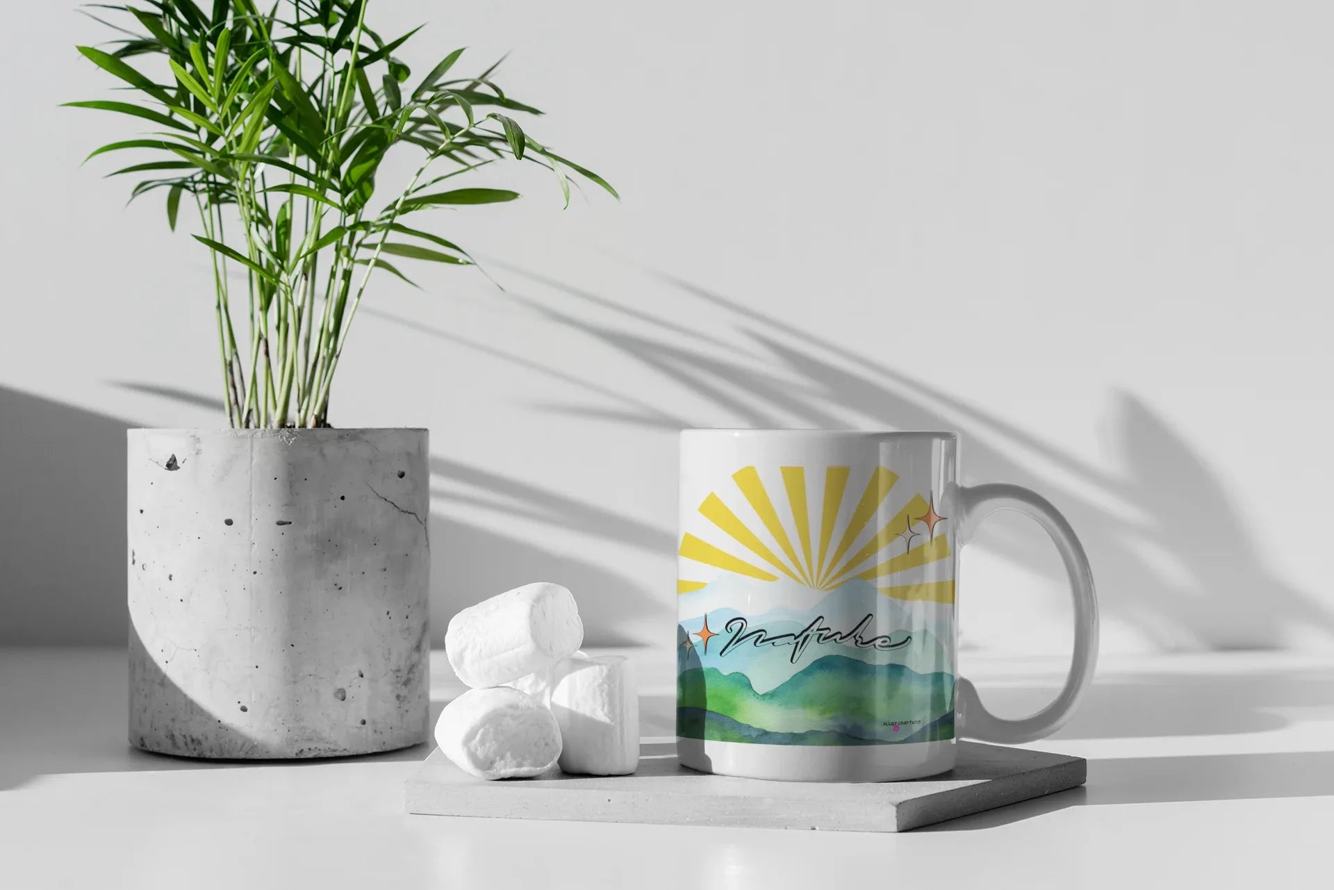 White coffee mug with sunrise landscape graphic, shown with handle facing right