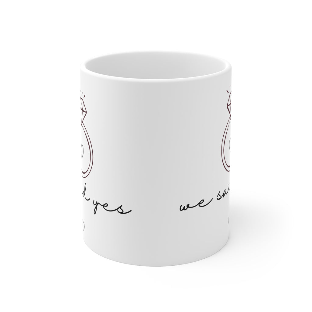 White coffee mug with partial diamond ring and "we said yes" printed on side