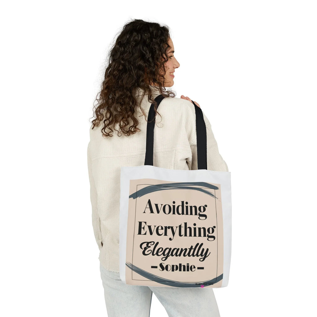 White canvas tote bag carried by model, "Avoiding Everything Elegantly" graphic