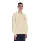 Cream crewneck sweatshirt with small chest logo, worn