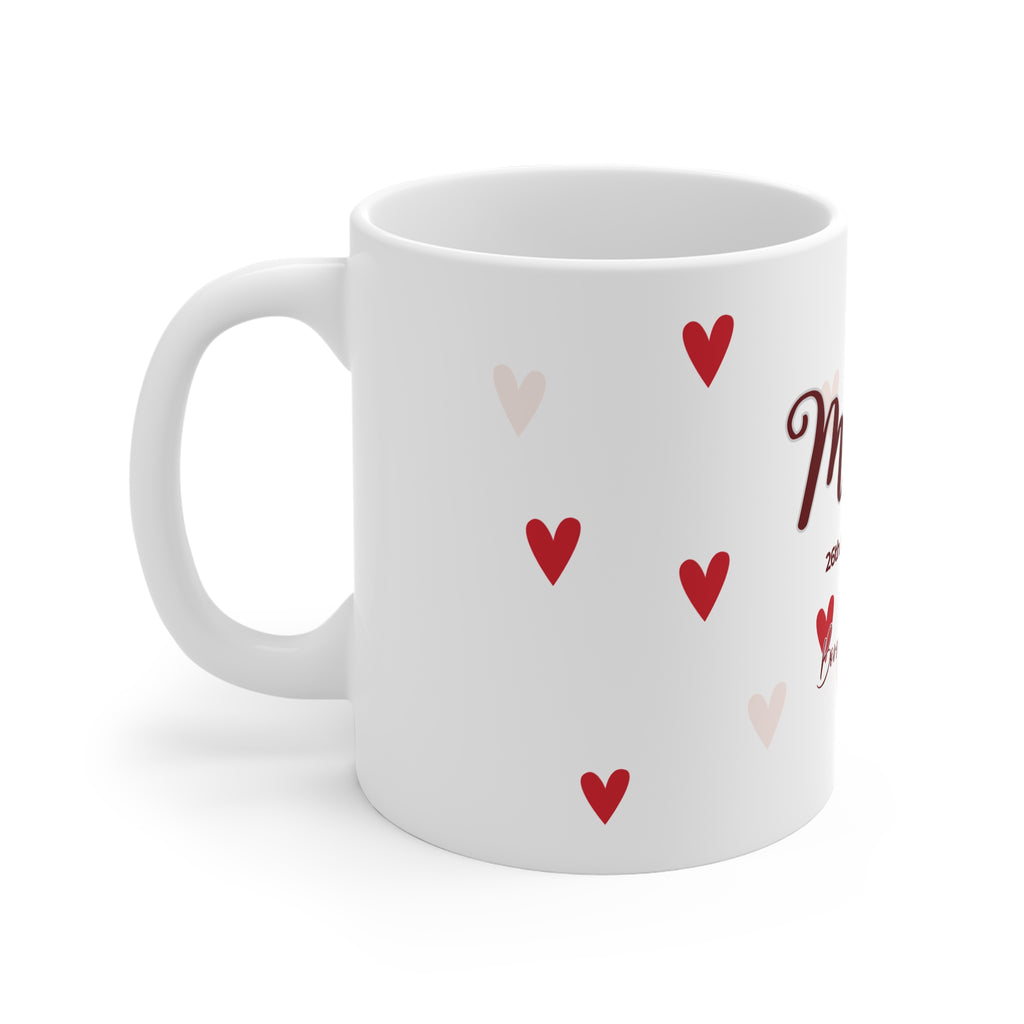 White mug with scattered red hearts pattern and partial name lettering on side.