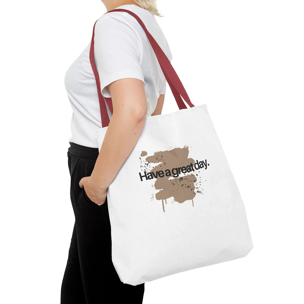 White canvas tote bag with red handles and brown splash “Haveagreatday.”