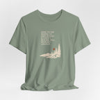 Sage green hiking T-shirt with woods scene graphic and quote text on front