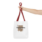 Red canvas tote bag held by top handles, showing brown splash “Haveagreatday.”