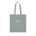 Light gray cotton tote bag with custom text "hey."
