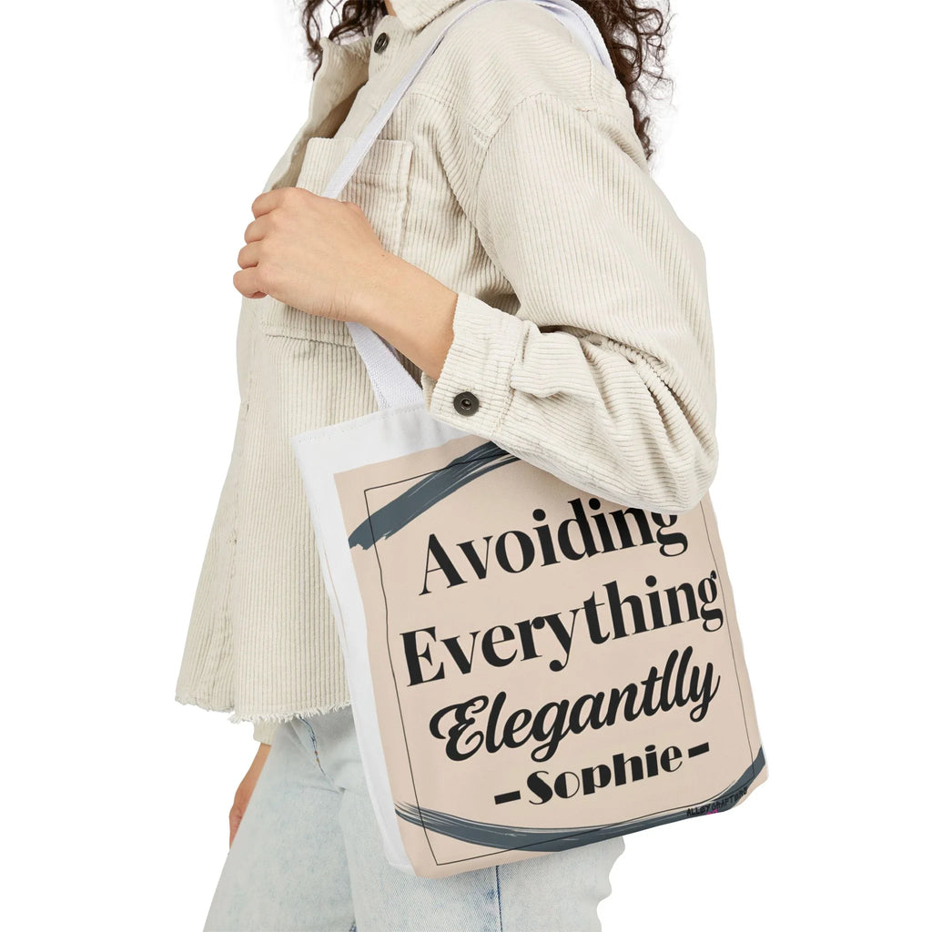 White canvas tote bag on shoulder, "Avoiding Everything Elegantly" lettering