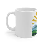 White coffee mug with partial sunrise rays and landscape print on the side
