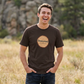 Dark brown crew-neck T-shirt with circular tree-ring badge graphic reading 'Seasoned'
