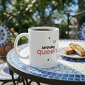White ceramic mug with 'birthday queen' text and hearts on front