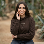 Dark brown hoodie with “delulu vibes” logo at chest, front pocket and drawstring hood.