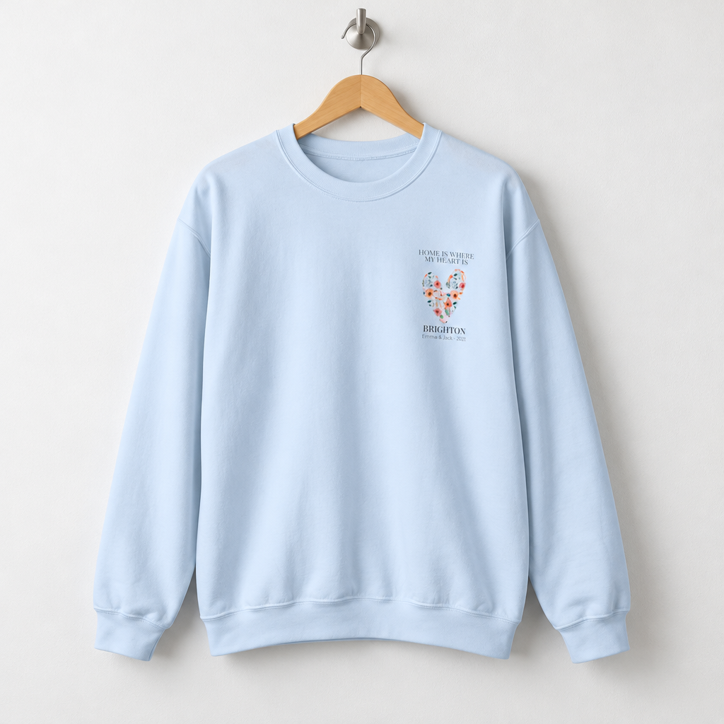 Light blue personalised sweatshirt with floral heart graphic and location text on chest
