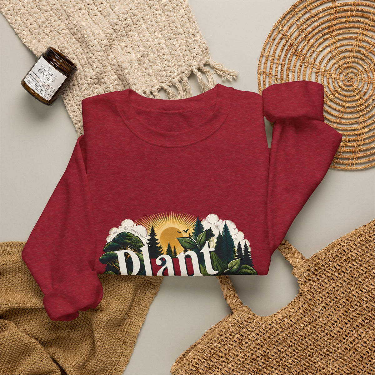 Unisex red sweatshirt laid flat with “Plant More Trees” nature graphic
