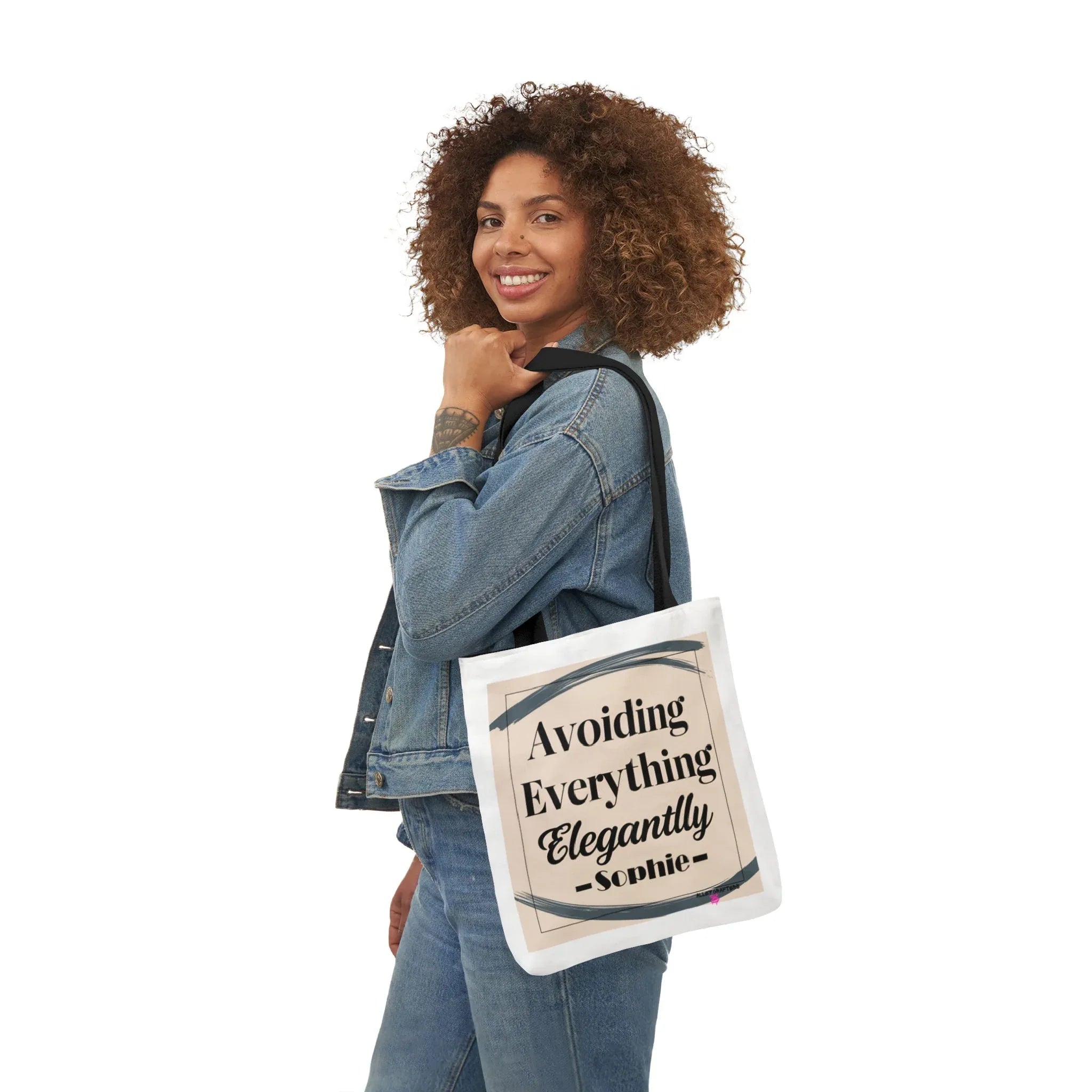 White canvas tote bag carried by model, "Avoiding Everything Elegantly" print