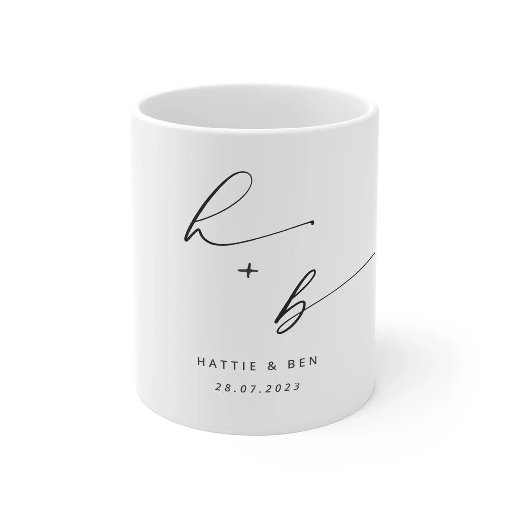 White ceramic mug with monogram h + b and date 28.07.2023, printed on front.