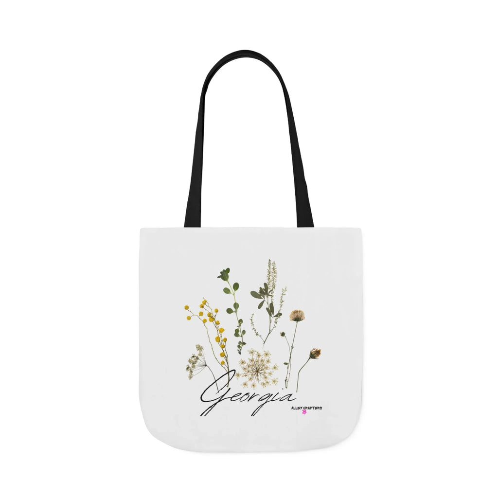 White canvas tote bag with black handle straps, botanical print, and cursive "Georgia"