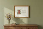 Framed canvas print with house illustration and text, shown on a wall