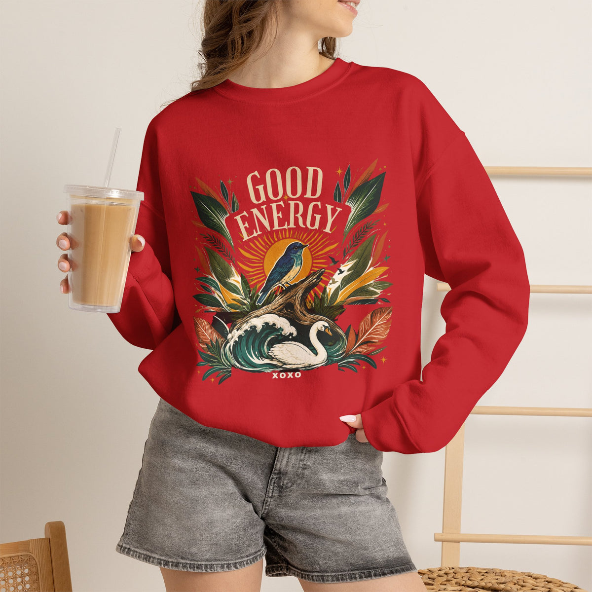 Red unisex sweatshirt with botanical “Good Energy” front graphic