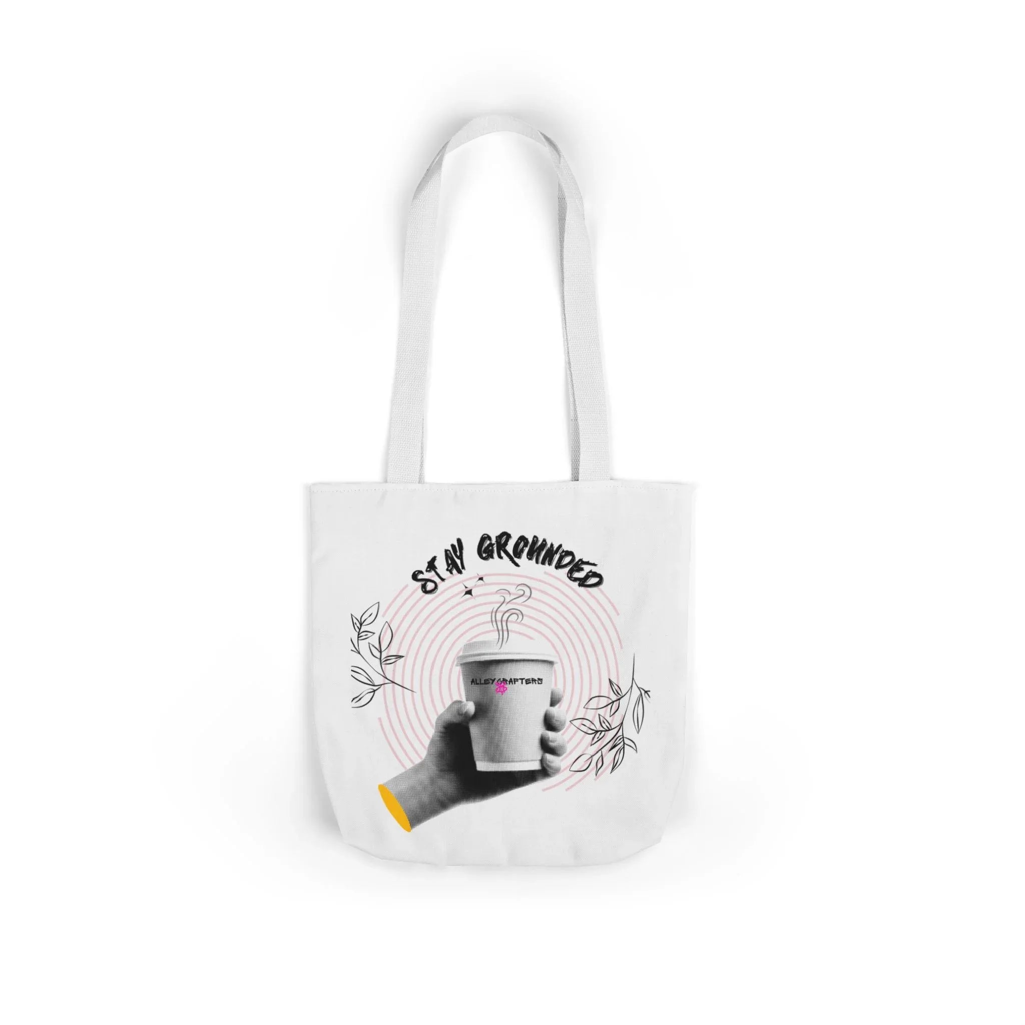 White coffee tote with white handles, “STAY GROUNDED” coffee mug graphic on front