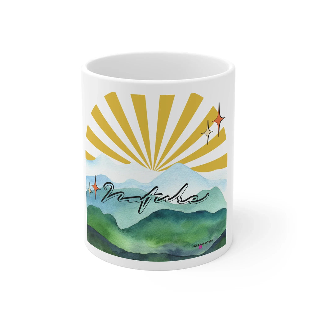 White coffee mug featuring sunrise rays over green mountain watercolor landscape