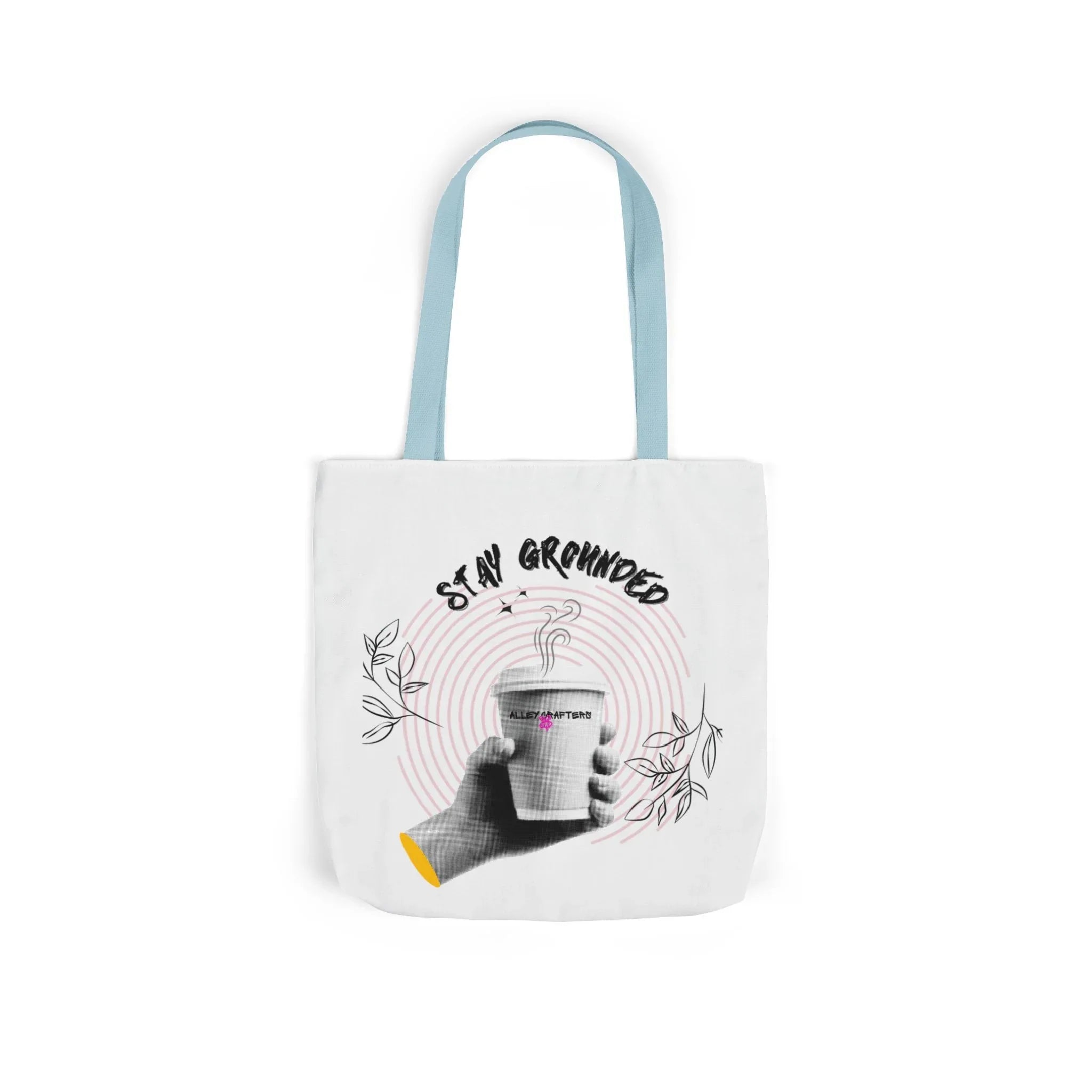 White coffee tote with light blue handles, “STAY GROUNDED” coffee mug print with leaves