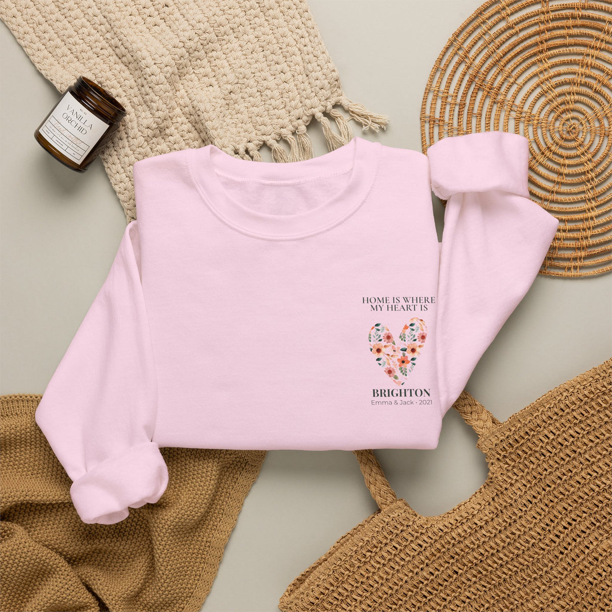Light pink sweatshirt with floral heart location graphic and printed text on chest
