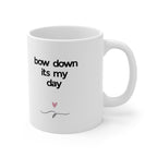 White ceramic mug with 'bow down its my day' text and heart-and-bow drawing