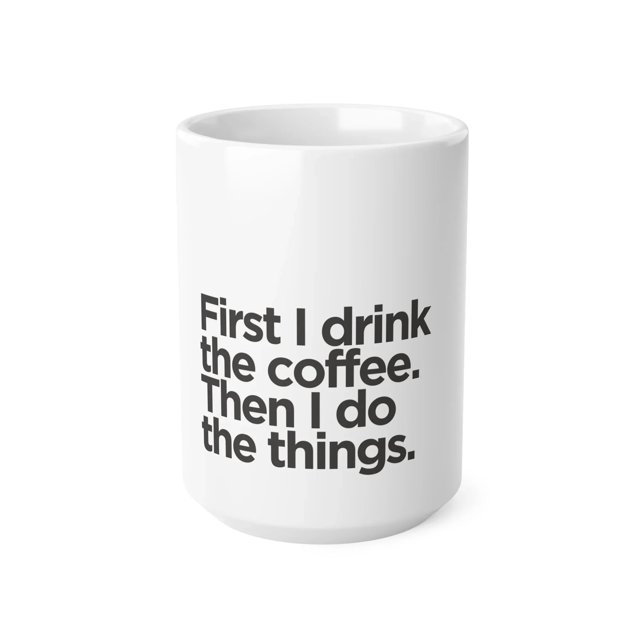 White ceramic coffee mug front view with black quote: First I drink the coffee.