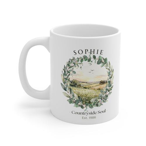 White ceramic coffee mug with countryside wreath graphic and name "SOPHIE"