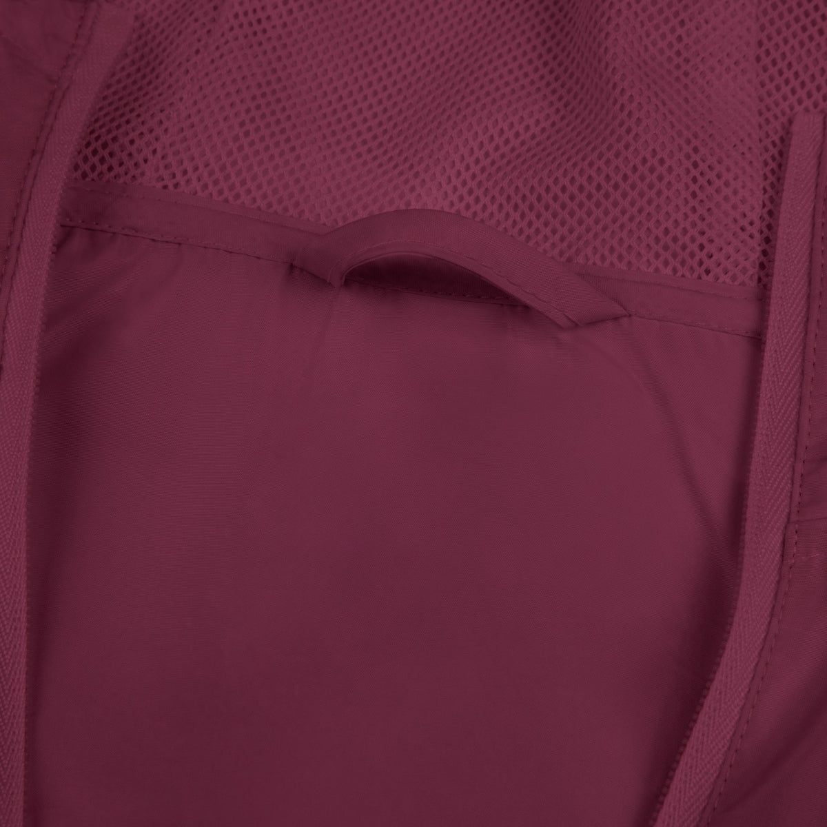Maroon windbreaker jacket lining and pocket seam close-up