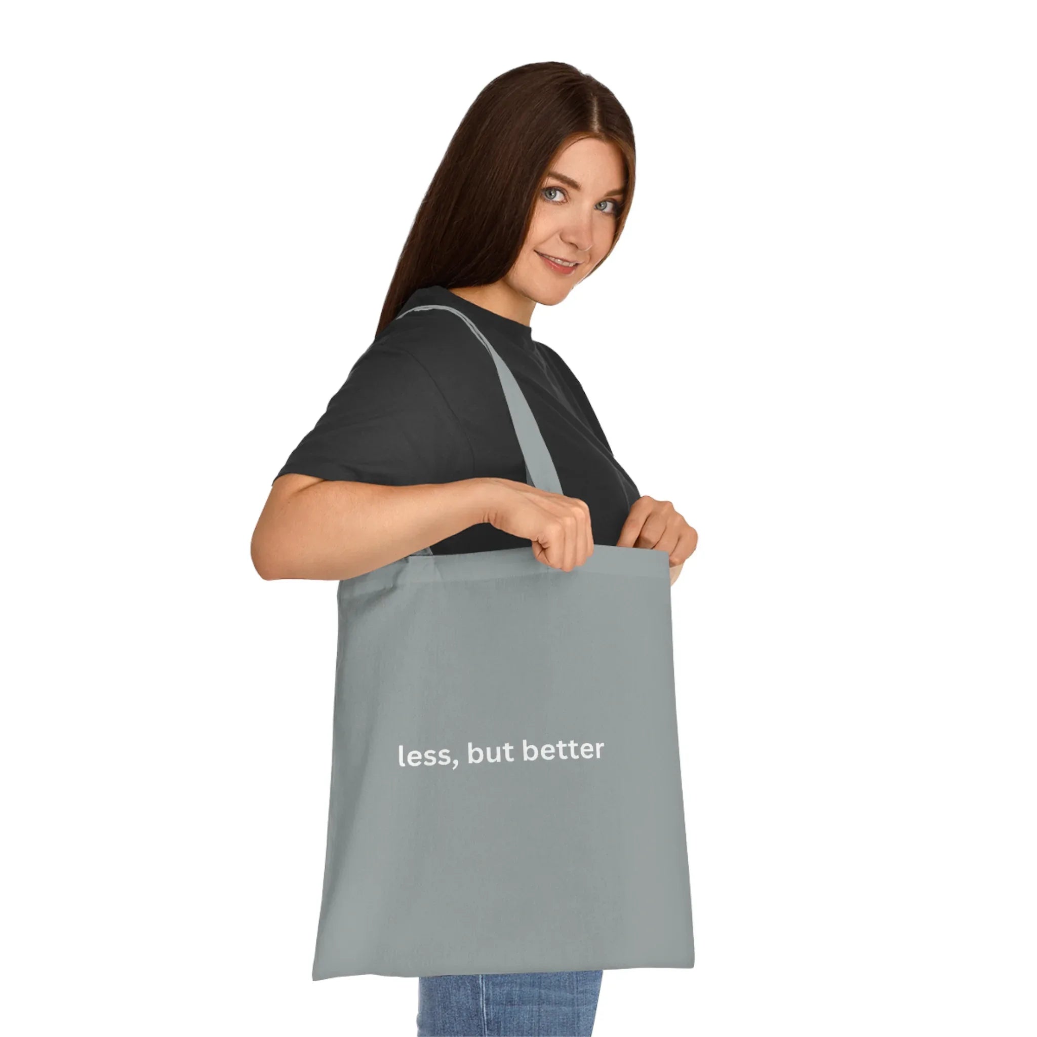 Grey cotton tote bag with long handles and 'less, but better' front print.