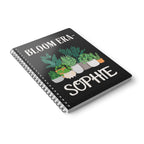 Personalised A5 lined notebook angled view with black cover, floral pots and SOPHIE.