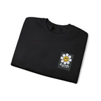 Black crewneck sweatshirt with flower smiley square patch at center chest.