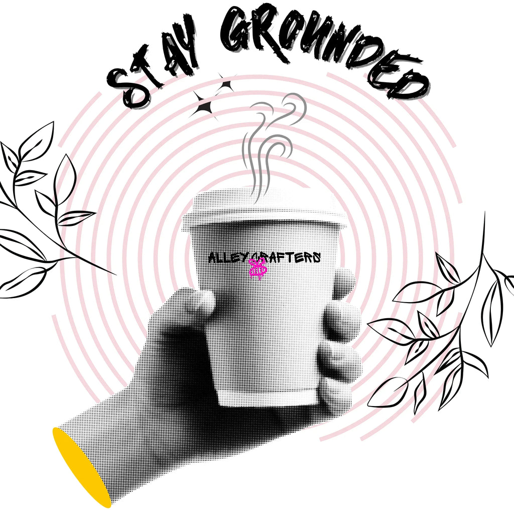 Close-up of white tote front print: “STAY GROUNDED” with coffee mug illustration and leaves