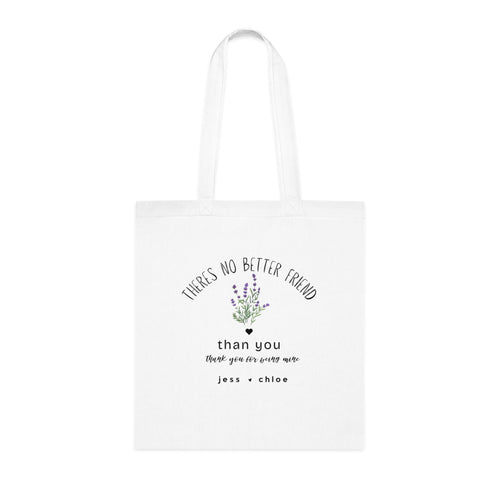 White canvas tote bag with arched friendship text, floral graphic, and “than you” message