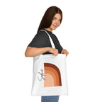 White cotton tote bag worn, front shows terracotta abstract arch print and black signature