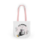 White coffee tote with pink handles, “STAY GROUNDED” coffee mug graphic on front