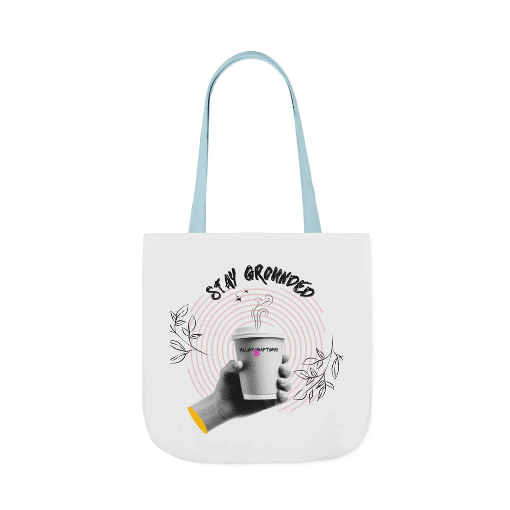White coffee tote with light blue handles, “STAY GROUNDED” coffee mug design on front