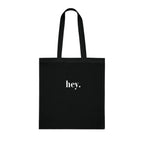 Black cotton tote bag with custom text "hey."