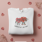 White hoodie sweatshirt laid flat with front cartoon heart graphic and drawstring hood