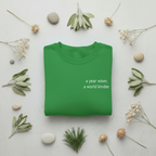 Green crewneck sweatshirt with 'a year wiser, a world kinder' chest print