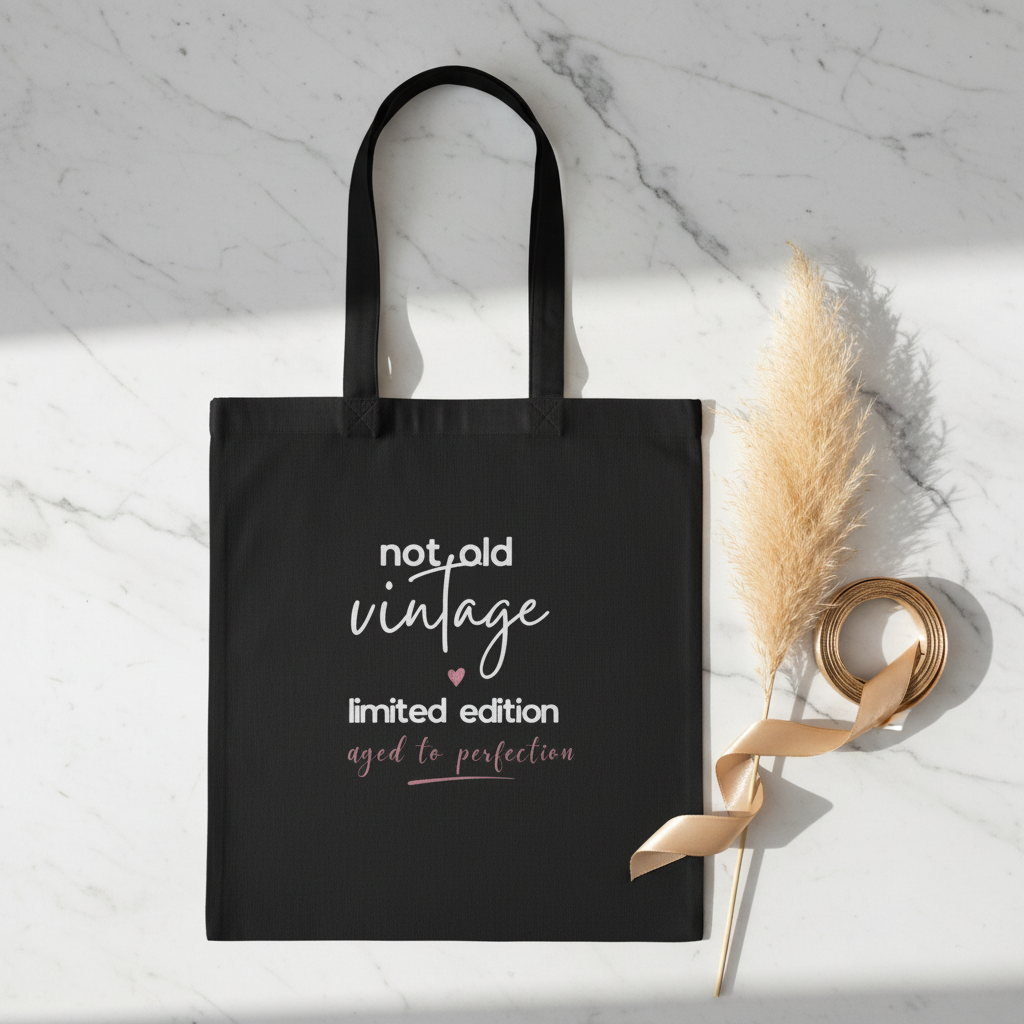 Black canvas tote bag with 'not old vintage' and 'limited edition' print