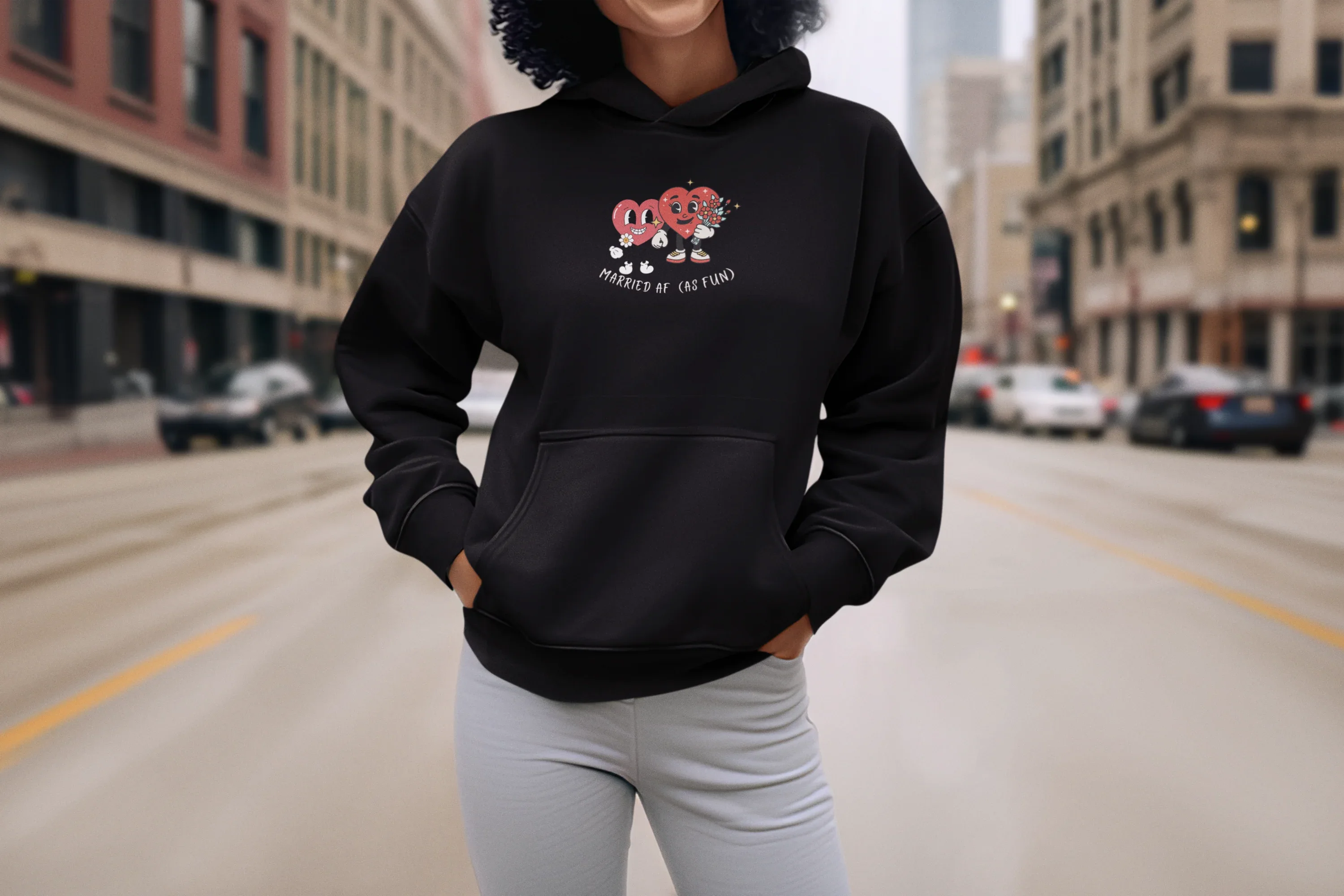 Black hoodie sweatshirt with kangaroo pocket and hood, front cartoon heart graphic