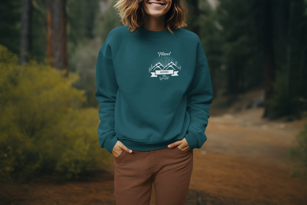Teal crewneck sweatshirt with long sleeves and chest adventure graphic on model